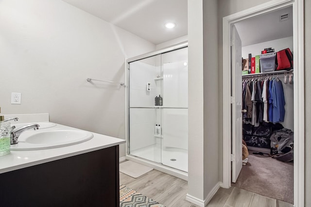 115 Rock Creek Ln, Terrell, TX 75160 - full bathroom with wood finished floors, a stall shower, a walk in closet, and double vanity