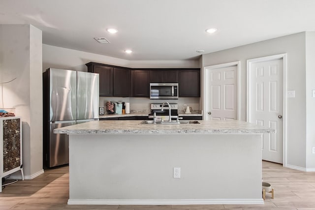115 Rock Creek Ln, Terrell, TX 75160 - kitchen with stainless steel appliances, a sink, dark brown cabinetry, light countertops, and baseboards