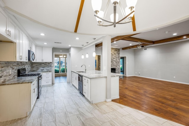 kitchen with black microwave, range with gas stovetop, a sink, dishwasher, and a chandelier