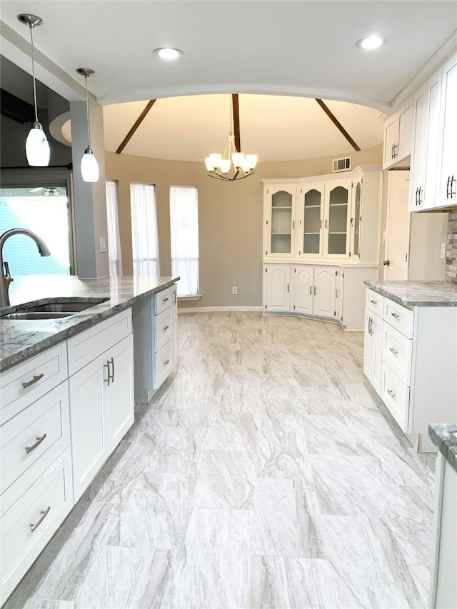 kitchen featuring a sink, white cabinetry, light stone counters, and recessed lighting