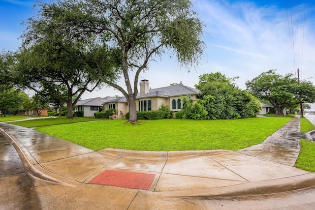 view of front of house with a front yard and a chimney