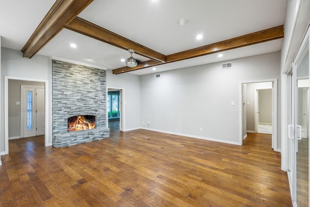 unfurnished living room featuring beamed ceiling, wood finished floors, a fireplace, recessed lighting, and baseboards