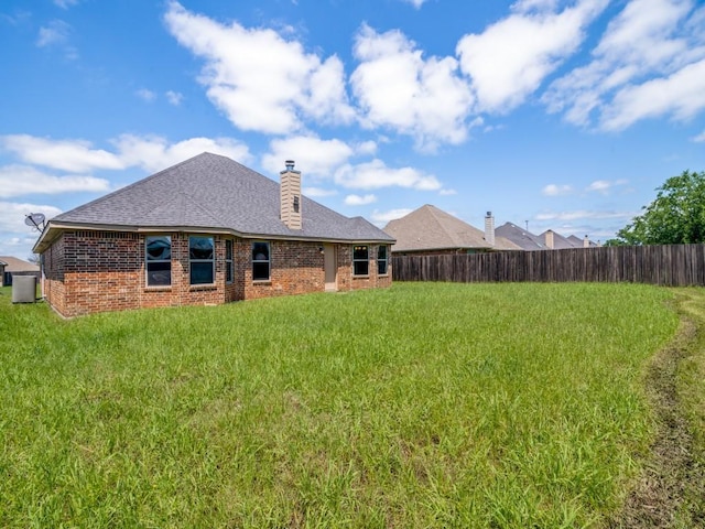 313 W Alene Dr, Mabank, TX 75147 - back of house with central AC, brick siding, a chimney, and roof with shingles