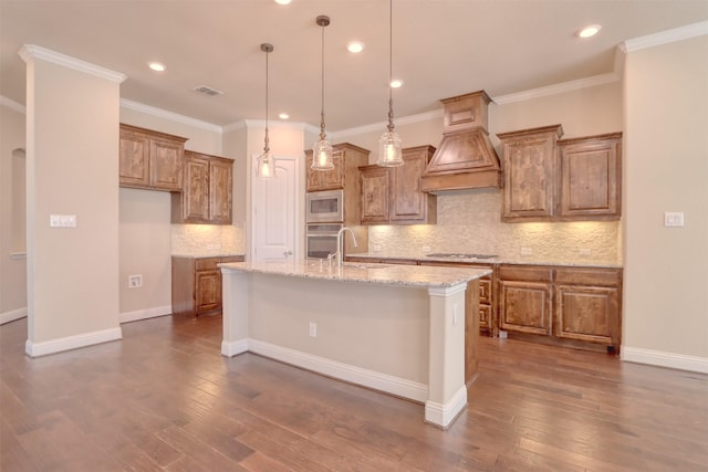 1306 Prato Ave, Mclendon Chisholm, TX 75032 - kitchen featuring stainless steel appliances, brown cabinets, custom range hood, a kitchen island with sink, and backsplash