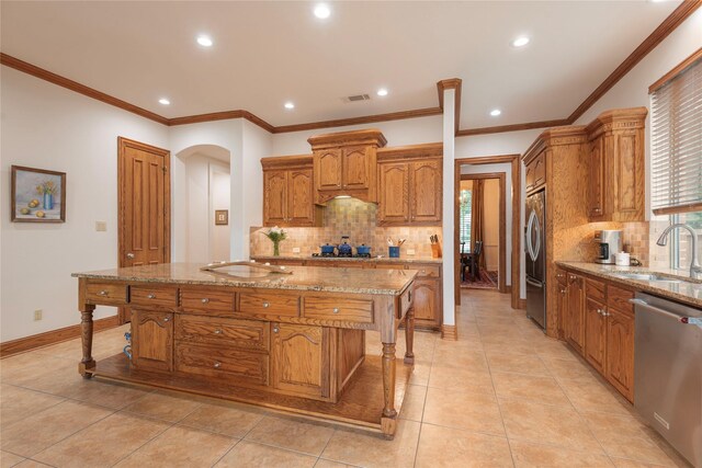 1607 Navarro Ct, Allen, TX 75013 - kitchen featuring appliances with stainless steel finishes, a sink, backsplash, arched walkways, and recessed lighting