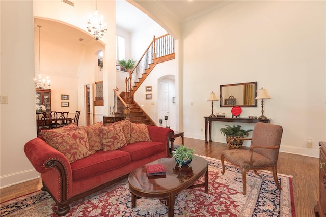 1607 Navarro Ct, Allen, TX 75013 - living area featuring arched walkways, a chandelier, stairs, a high ceiling, and baseboards