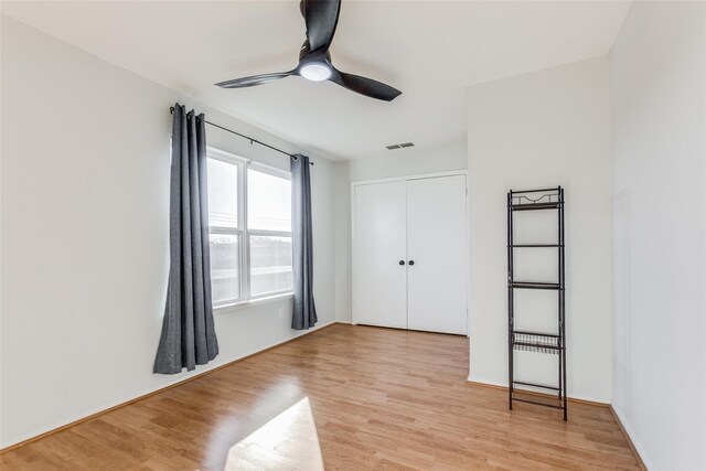 323 Towne House Ln, Richardson, TX 75081 - unfurnished bedroom with light wood-style floors, a closet, and a ceiling fan