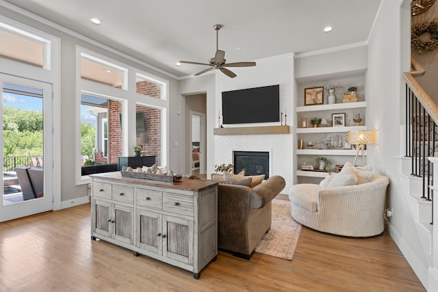 5000 Brush Hill Rd, Carrollton, TX 75010 - living room featuring a glass covered fireplace, light wood-type flooring, ceiling fan, recessed lighting, and stairway
