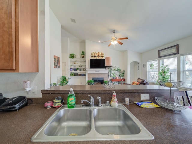 3929 Bonita Springs Dr, Fort Worth, TX 76123 - kitchen featuring a sink, dark countertops, lofted ceiling, ceiling fan, and a tile fireplace