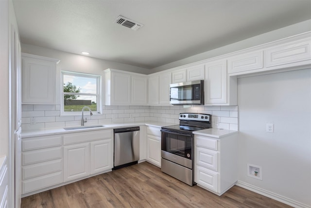 943 Lone Star Rd, Whitesboro, TX 76273 - kitchen featuring stainless steel appliances, a sink, tasteful backsplash, white cabinets, and recessed lighting