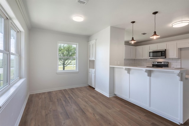 943 Lone Star Rd, Whitesboro, TX 76273 - kitchen with stainless steel appliances, wood finished floors, decorative backsplash, a kitchen bar, and crown molding