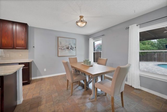 2200 Bantry Ln, Arlington, TX 76002 - dining room featuring baseboards, stone finish floors, and a textured ceiling