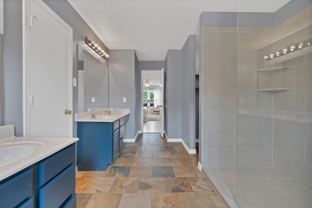 2200 Bantry Ln, Arlington, TX 76002 - ensuite bathroom with stone tile flooring, two vanities, tiled shower, baseboards, and a ceiling fan