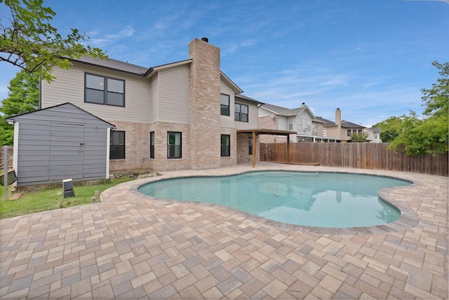 2200 Bantry Ln, Arlington, TX 76002 - view of swimming pool with a patio, a storage unit, a fenced backyard, and an outbuilding