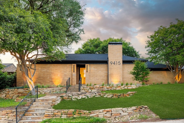 9415 Hill View Dr, Dallas, TX 75231 - view of front of house with brick siding, a chimney, a front lawn, and roof with shingles