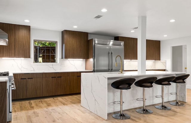 9415 Hill View Dr, Dallas, TX 75231 - kitchen with premium appliances, modern cabinets, light wood-type flooring, decorative backsplash, and recessed lighting