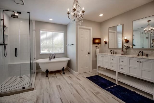2505 Wilma Ln, Plano, TX 75074 - full bathroom with a chandelier, a shower stall, double vanity, a freestanding tub, and wood finished floors
