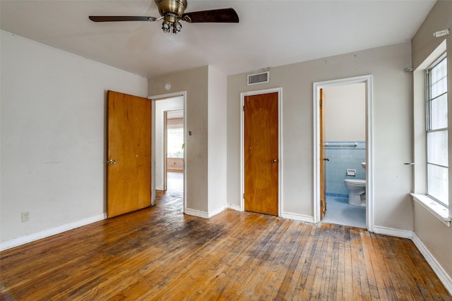 1231 Arizona Ave, Dallas, TX 75216 - unfurnished bedroom with hardwood / wood-style floors, multiple windows, and ensuite bathroom