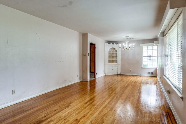 1231 Arizona Ave, Dallas, TX 75216 - unfurnished room with a chandelier, light wood-type flooring, and baseboards