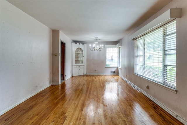 1231 Arizona Ave, Dallas, TX 75216 - unfurnished dining area with a chandelier, light wood-style floors, and baseboards