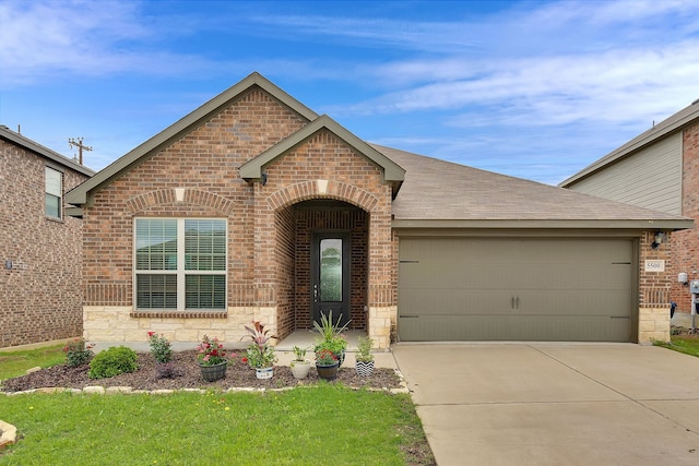 5500 Persimmon Dr, Denton, TX 76207 - view of front of property featuring brick siding, driveway, an attached garage, and stone siding
