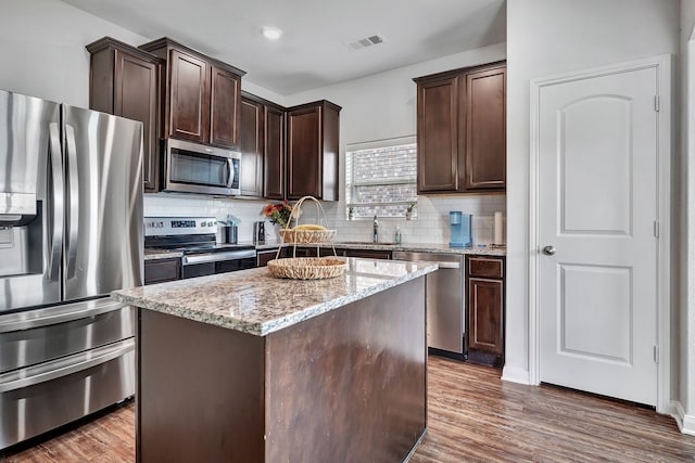 5500 Persimmon Dr, Denton, TX 76207 - kitchen with appliances with stainless steel finishes, dark brown cabinetry, and tasteful backsplash