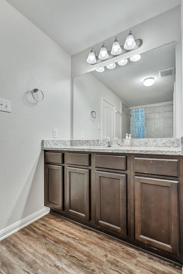 5500 Persimmon Dr, Denton, TX 76207 - full bathroom with wood finished floors, tiled shower, baseboards, and vanity