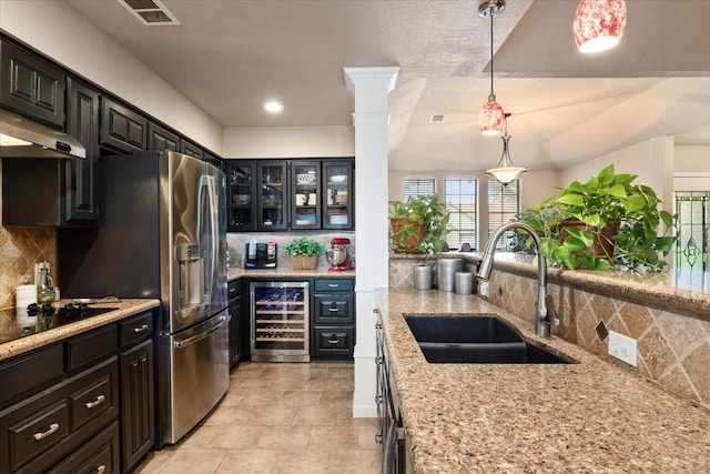 10013 Stoneleigh Dr, Benbrook, TX 76126 - kitchen featuring beverage cooler, a sink, decorative backsplash, glass insert cabinets, and light stone counters