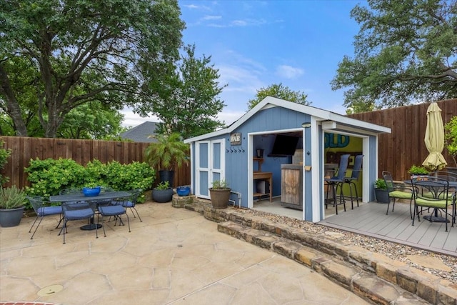 10013 Stoneleigh Dr, Benbrook, TX 76126 - view of outbuilding with outdoor dining space, a fenced backyard, and an outdoor structure