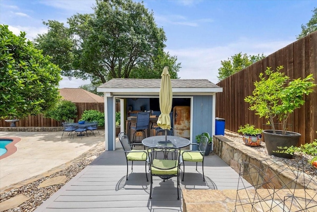 10013 Stoneleigh Dr, Benbrook, TX 76126 - wooden terrace with outdoor dining area, a fenced backyard, and an outdoor structure
