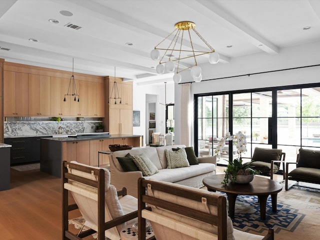 living room featuring a chandelier, wood finished floors, and beamed ceiling