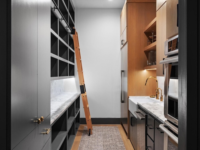 clothes washing area featuring a sink and light wood finished floors