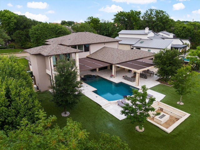view of pool featuring a patio area, a yard, and a pool with connected hot tub