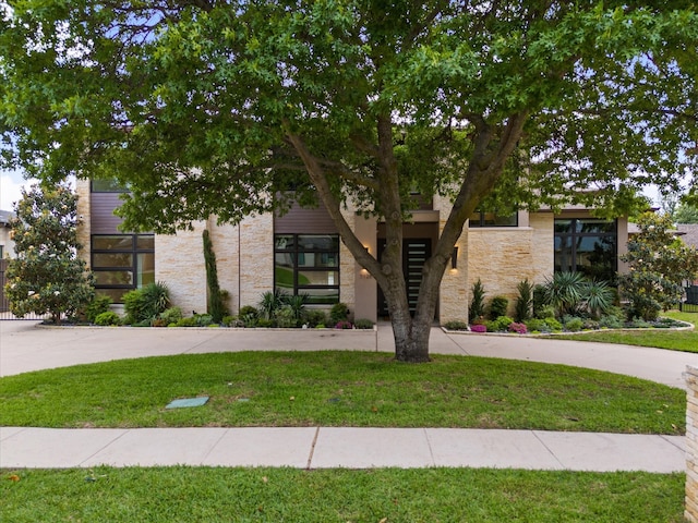 view of front of home featuring stone siding and a front yard