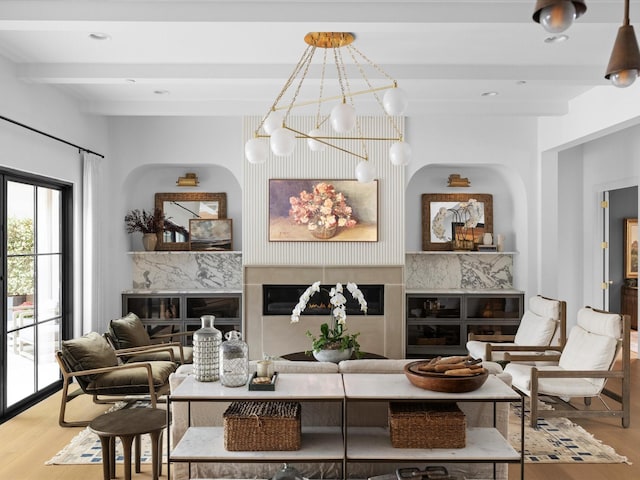living room with wood finished floors, a high end fireplace, a chandelier, beamed ceiling, and recessed lighting