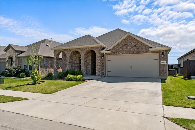 3008 Aransas Ave, Aubrey, TX 76227 - french country style house with an attached garage, a front lawn, brick siding, driveway, and central AC