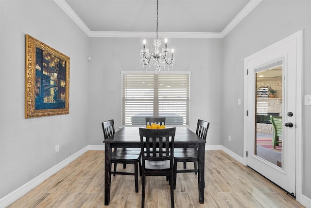 dining space with a chandelier, crown molding, light wood finished floors, and baseboards