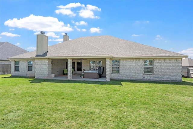 back of property with a patio, ceiling fan, brick siding, a chimney, and roof with shingles