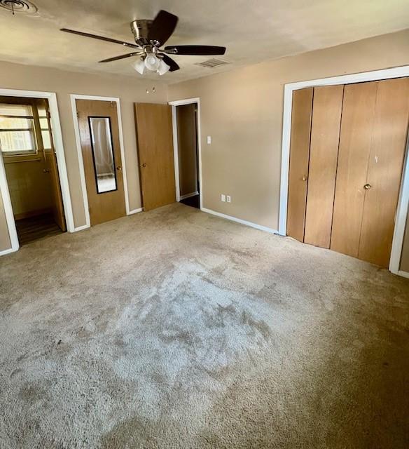 2142 Woodard St, Abilene, TX 79605 - unfurnished bedroom with carpet flooring, baseboards, ceiling fan, and ensuite bathroom