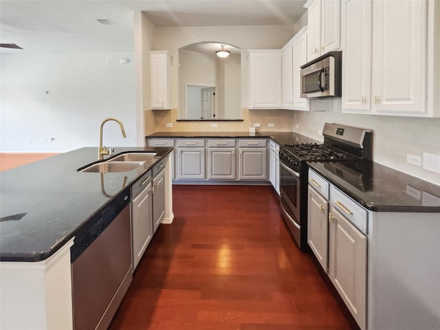 825 Lake Worth Trl, Little Elm, TX 75068 - kitchen featuring stainless steel appliances, a sink, dark wood-style flooring, and white cabinetry