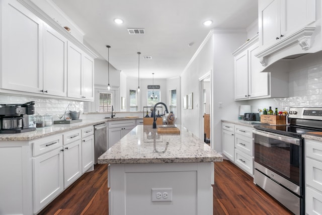 kitchen with appliances with stainless steel finishes, a peninsula, a sink, white cabinets, and recessed lighting