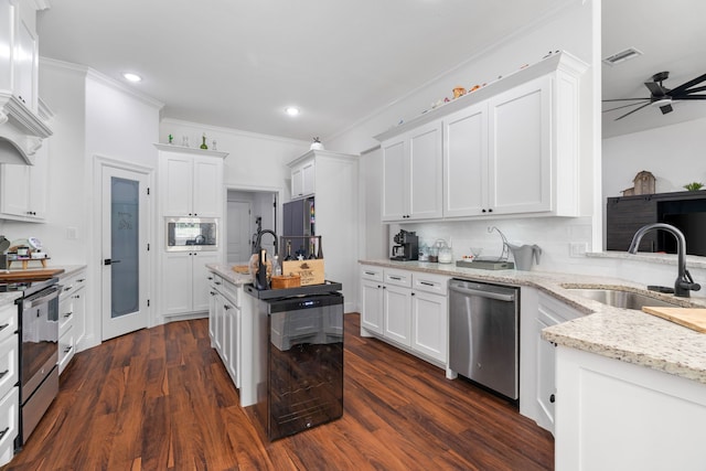 kitchen featuring appliances with stainless steel finishes, a sink, wine cooler, ceiling fan, and white cabinets