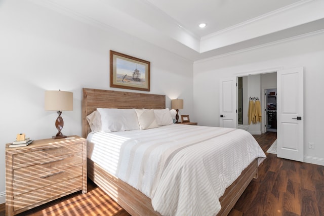 bedroom with crown molding, wood finished floors, recessed lighting, baseboards, and a tray ceiling
