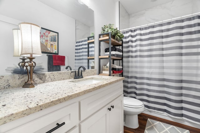 bathroom featuring toilet, vanity, wood finished floors, and curtained shower