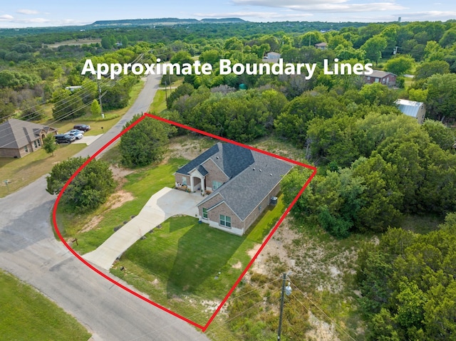 aerial view of property and surrounding area with property boundaries highlighted and a heavily wooded area