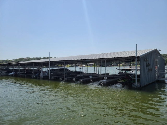 dock area with boat lift and a water view