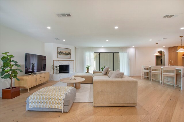 3314 Norcross Ln, Dallas, TX 75229 - living room featuring a premium fireplace, recessed lighting, and light wood-style flooring