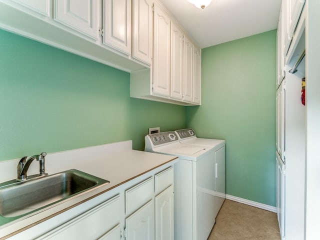 clothes washing area with cabinet space, washer and dryer, light tile patterned floors, and baseboards