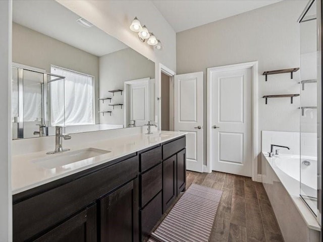 1044 Pitch Pine St, Hickory Creek, TX 75065 - full bathroom featuring a bath, a stall shower, double vanity, and wood finished floors