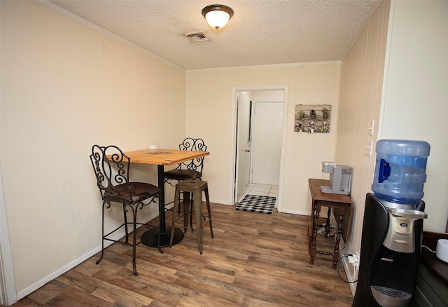 1217 Randy Dr, Graham, TX 76450 - dining space featuring wood finished floors, ornamental molding, a textured ceiling, and baseboards
